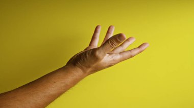 Adamın sol eli, canlı sarı bir arka plana karşı kaldırıldı. Bu da açık parmakları bir jest olarak gösteriyor..