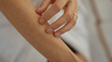 Spa odasında koluna dokunan bir kadın, güzellik ve sağlığın altını çiziyor, yakın plan çekimleri yapıyor..