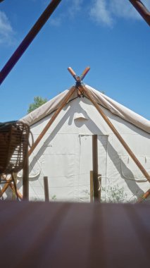 Arka planda parlak mavi bir gökyüzü olan, Afrika kampı macerasında bir çadır..
