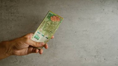 Arjantin 'de elle tutulan Arjantin pesolarına karşı somut bir arka plan gösterimi para birimi alışverişi