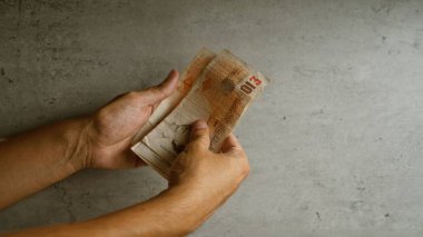 İngiltere 'de İngiliz sterlinlerini beton bir zemine dayayıp para birimlerini vurguluyorlar.