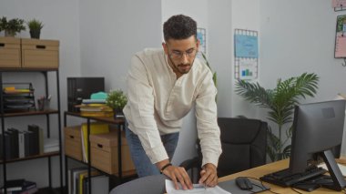 Ofis ortamında çalışan yakışıklı İspanyol bir adam. Etrafı bitkilerle, raflarla ve bilgisayarla çevrili. Masasına yaslanmış belgeleri inceliyor..