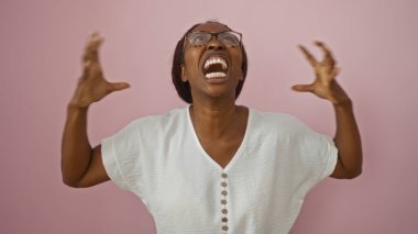 Elleri havada pembe arka planda bağıran bir kadın.