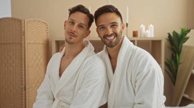 Beyaz cüppeli gülümseyen adamlar rahat bir kaplıcada rahatlayıp huzurlu bir sağlık ortamında bir aşk ve yakınlık anı yaratmaktan hoşlanırlar..