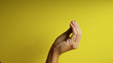 Canlı sarı arkaplana karşı, iletişim, kültür ve ifadeyi vurgulayan yakın plan bir italyan hareketi yapmak