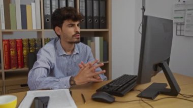 Düzgün bir ofis ortamında bilgisayarla uğraşan yakışıklı bir adam.