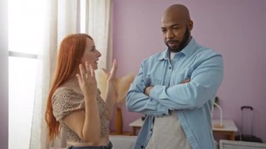 Irklar arası bir çift, evlerinin oturma odasında ciddi bir şekilde tartışıyor içeride bir erkekle konuşan bir kadınla aşk ve ilişki dinamikleri sergiliyorlar.