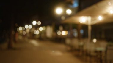Mallorca 'da bir sokak kafesinde Bokeh ışıkları ile odaklanmış bir gece sahnesi.