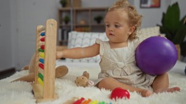 Küçük kız renkli abaküs ve mor topla yatak odasında oynuyor.