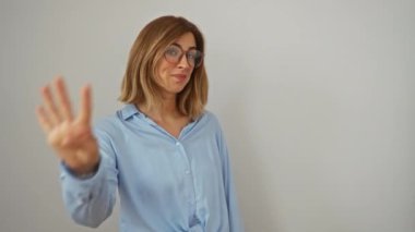 Sarı saçlı, gözlüklü, dört parmakla işaret eden, beyaz arka planda izole edilmiş, gülümseyen ve kendine güvenen dört numarayı gösteren genç bir kadın.