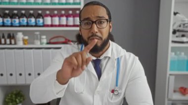 Tıp bürosunda steteskopla el kol hareketi yapan doktor net iletişim ve uzmanlığı vurguladı..