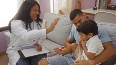 Doktor, kontrol sırasında babası tarafından oturma odasında tutulan çocuk, erkek, kadın, çocuk, ev, gülümseme, sağlık, randevu, etkileşim...