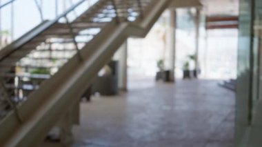 Bulanık arka plan, modern mimariyi ve yeşilliği göstererek sakin bir atmosfer yaratıyor..