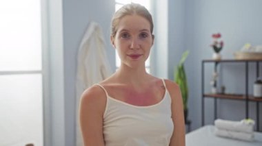 Güzellik merkezinde gülümseyen ve rahatlatan sarı saçlı bir kadın.