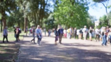 Roma 'daki villa borghese bahçelerinde bulanık kalabalık. Ağaçlar bokeh ve açık havada güneşli yollar..