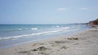 Bulanık plaj sahnesi. Yaz günü kumlara vuran dalgalar.