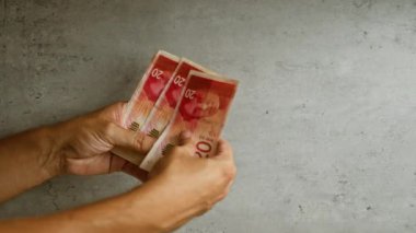 İsrail şekellerini somut bir arkaplana karşı sayan adam, İsrail 'deki mali işlemleri ve para akışını gösteriyor.