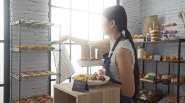Beyaz bluzlu, mavi önlüklü, fırınlanmış mallarla çevrili, kapalı bir pastanede hamur işleri düzenleyen bir kadın, Çin 'de samimi ve ilginç bir iş ortamının özünü yakalıyor.