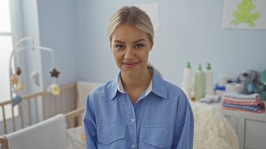 Bebek beşiği olan rahat bir yatak odasında gülümseyen bir kadın. Etrafı sükunetle çevrili. Bakıcı bir evde sıcaklığı ve huzuru somutlaştırıyor..