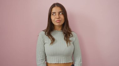 Pembe bir duvara poz veren esmer kadın, derin bir ifadeyle esmer kadın, soyutlanmış arka plan, genç ve çekici, İspanyol kadın, yetişkin kadın, modern tarz, gündelik kıyafet