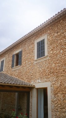 İspanya 'nın dışındaki Akdeniz taştan evi. Mavi panjurları ve terasotta çatısı, kırsal mimari tasarımı ön plana çıkarıyor..