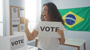 Orta yaşlı bir kadın Brezilya bayrağıyla süslenmiş bir Brezilya seçim kolejinin içinde elinde 