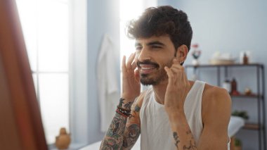 Genç, yakışıklı, sakallı ve dövmeli İspanyol bir adam kaplıcada rahatlatıcı bir anın tadını çıkarıyor..