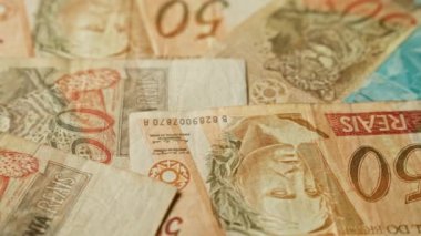 Brezilya banknotlarında çeşitli reais değerleri gösteriliyor. Farklı tasarımlar sergileniyor. Tarihi figürler ve yerli hayvanlarla ilgili ayrıntılı detaylar var..