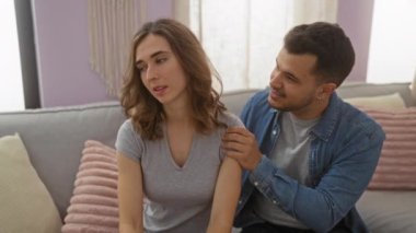 Erkek, kadını gülümsetiyor ve birlikte geçirdikleri sevgi dolu bir anda evlerinin rahat oturma odasında ona şefkatle sarılıyor.