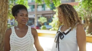 Kadınlar, arkadaşlar şehir parkında konuşuyor ve sarılıyorlar, şehirde açık havada eğleniyorlar, mutluluğu ve arkadaşlığı iletiyorlar..