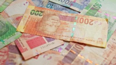 Güney Afrika banknotları Nelson Mandela 'nın çeşitli mezheplerde sergilenen, Güney Afrika' nın para ve ekonomik yönünü vurgulayan, dağınık bir düzende sergilenen.