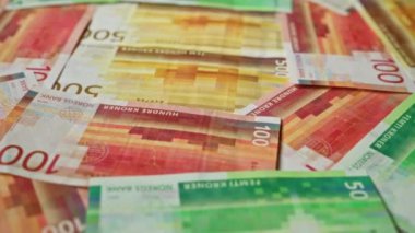 100, 50 ve 500 kron değerindeki Norveç banknotları bir yüzeye yayılarak canlı renkler ve Norveç 'in para birimini yansıtan karmaşık tasarımlar sergiliyor..