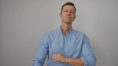 Kolları açık mavi gömlekli genç bir adam beyaz bir arka plana karşı, özgüven ve cazibe yayıyor..