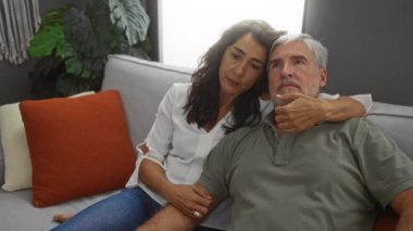 Orta yaşlı bir çift, sıcak bir oturma odasında sıcak ve samimi bir şekilde birlikte oturuyorlar..
