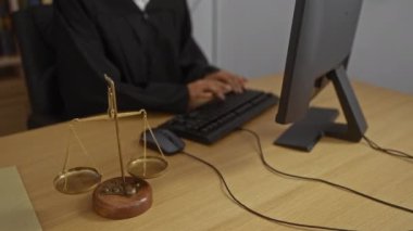 Kadın yargıç masada adalet terazisiyle ofiste çalışıyor, arka planda kitaplıklar olan profesyonel bir iş ortamı sergiliyor..
