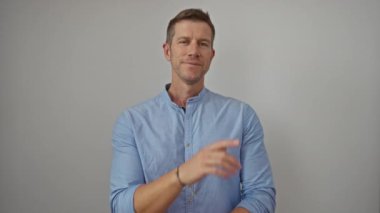 Mavi gömlekli yakışıklı adam özgüvenle ayakta duruyor. Özenli zarafet ve çekiciliğini ifade ediyor.