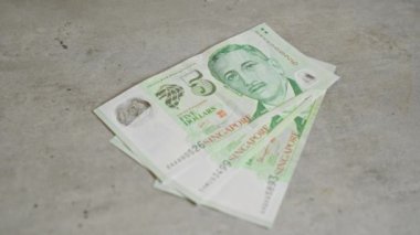 Singapur doları banknotları, Singapur 'da finansal konsepti ve ekonomiyi temsil eden somut bir yüzeyde yatıyor.