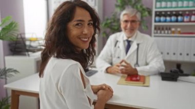 Sağlık odasında doktora gülümseyen kadın, hastane ortamında tıbbi danışma, klinik ortamında kadın ve erkek arasındaki etkileşimi teşvik etmeye odaklan.