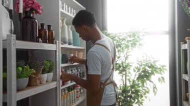 Erkek ve kadın, bitkiler, vazolar ve diğer dekoratif ürünlerle dolu iyi aydınlatılmış bir mağazada ev dekorasyonu konularını tartışıyor.