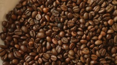 Kavrulmuş kahve çekirdeklerinin yakın çekimi kahverengi ve detaylı dokuların çeşitli tonlarını gözler önüne seriyor.