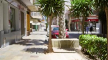 Arka planda odandan çıkarılmış arabalar, ağaçlar ve binalar olan bulanık şehir manzarası.