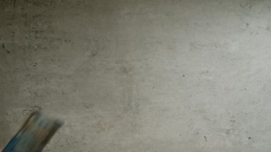 Şili pesolarını iki eliyle somut bir arka planda sayan adam.