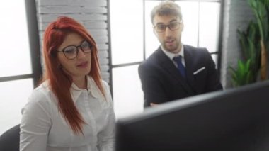 İş ortakları ofis masasında proje tartışıyorlar, takım elbiseli adam, gözlüklü kadın, modern iş yeri, takım çalışması odağı, işbirliği ortamı, profesyonel çevre.