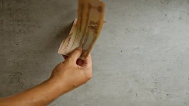 Yakın planda somut bir zemine karşı birkaç el ele tutuşmak, paranın altını çizmek ve Birleşik Arap Emirliklerinde para birimi işlemlerine odaklanmak.