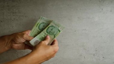 Adam iki elini de beton zemine karşı kullanarak tek başına dolar sayıyor.