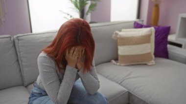 Kanepede oturan bir kadın, rahat oturma odasında rahat rahat ağlayan bir adamla birlikte duygusal ilişki desteği gösteriyor..