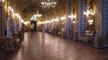 Galerideki bulanık kadın Doria Pamphilj 'de heykel ve dekorla çevrili lüks bir müzede hafif ışıklandırma ve zarif avizelerle süslenmiş..