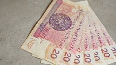 Polonya banknotları, narodowy banka polski 20 zloti banknotları ve karmaşık tasarımlar içeren beton bir yüzeye yayıldı.