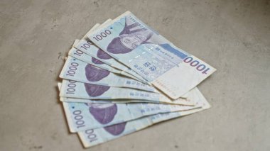 Güney Kore 'nin beton yüzey üzerindeki banknotları 1000 won' luk banknotları net bir şekilde gösteriyor..