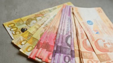 Beton yüzeyde sergilenen Filipin banknotları, renkli tasarımlarda çeşitli mezhepleri gösteriyor.